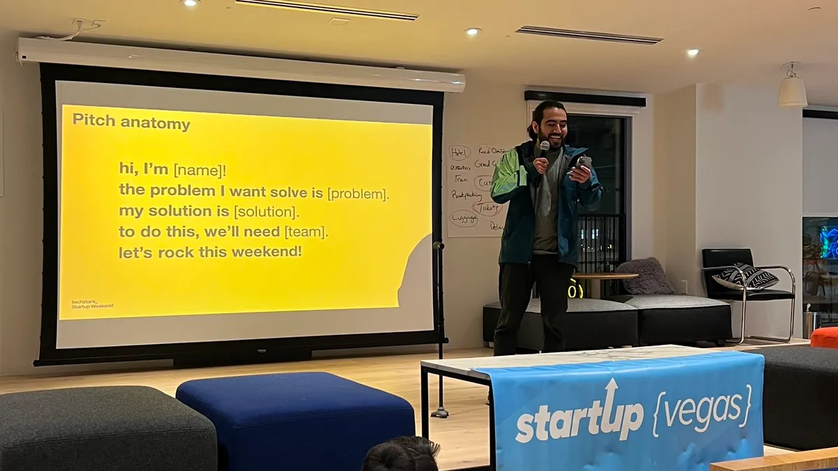 Victor presenting on stage with a cane
